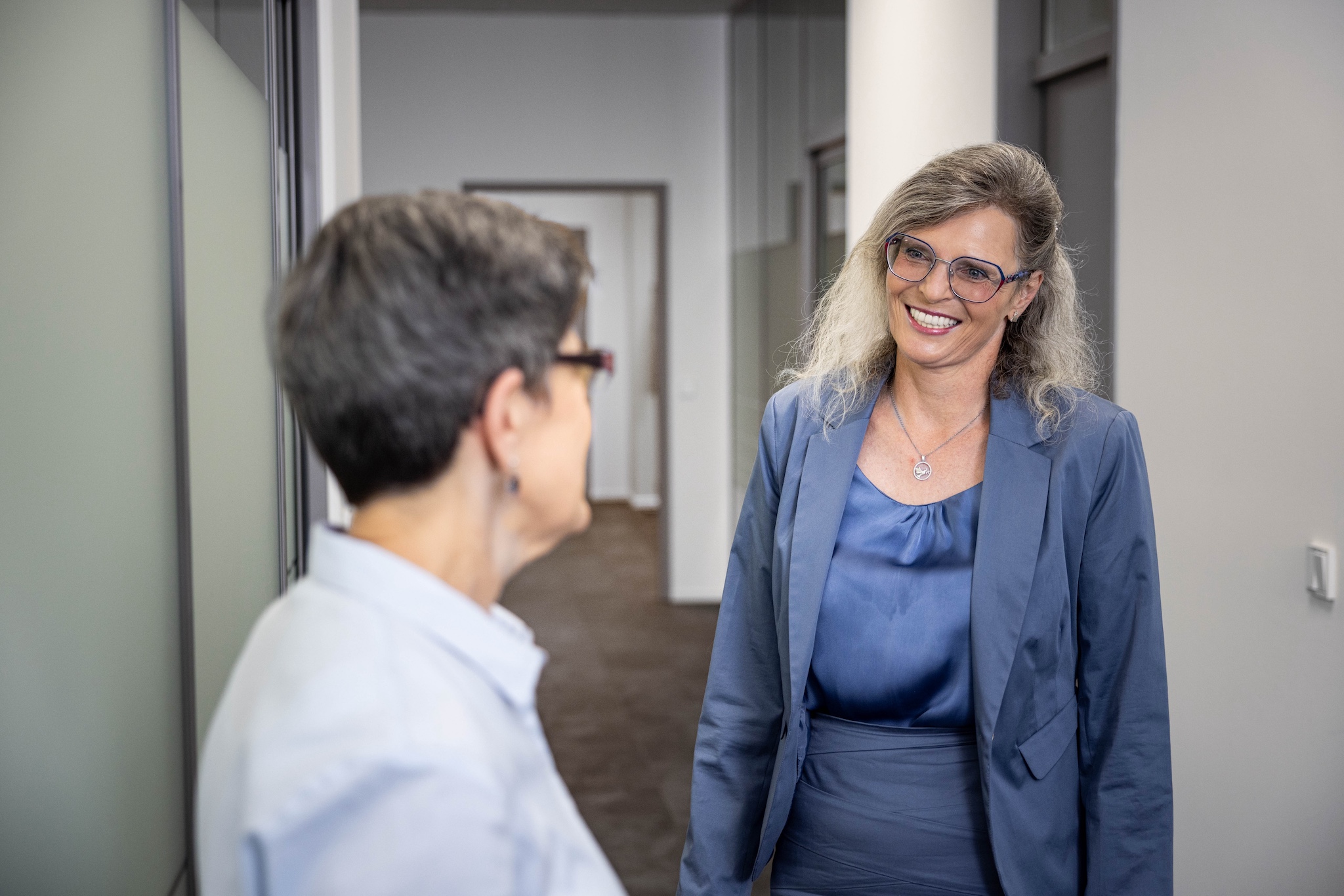 Zwei Mitarbeiterinnen unterhalten sich im Gang